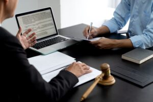 Lawyer explaining planned legal work to assistant to prepare documents or a contract in the office with a computer on the desk
