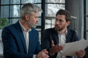 businessmen arguing about bad contract in office men colleagues partners dispute incorrect document failed transaction deal conflict problem shouting break agreement